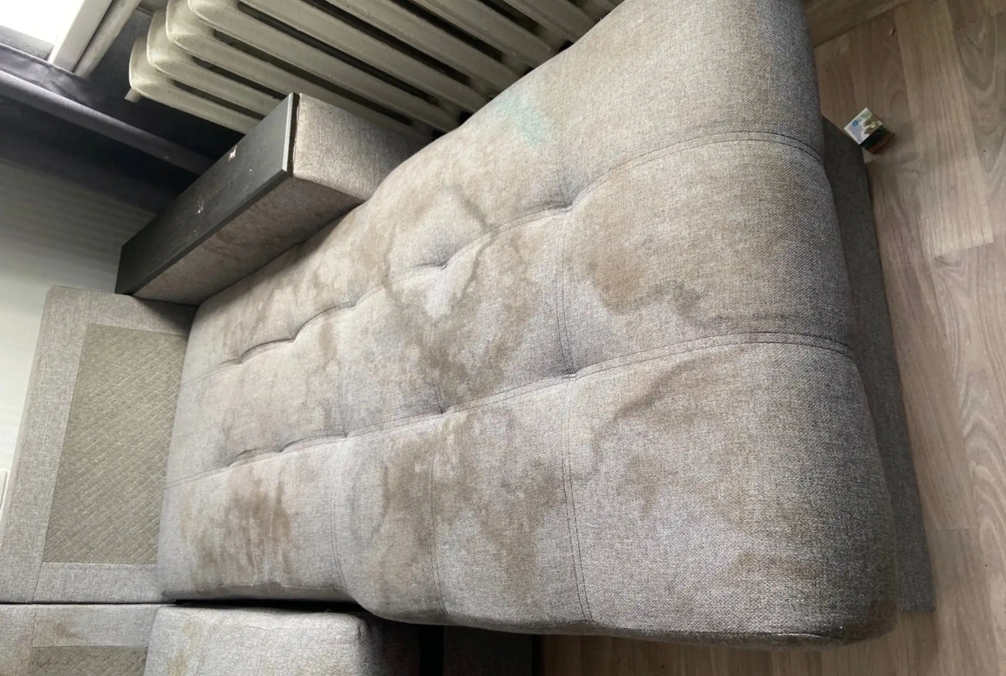 Verschmutztes graues Sofa vor der Polsterreinigung in Krefeld